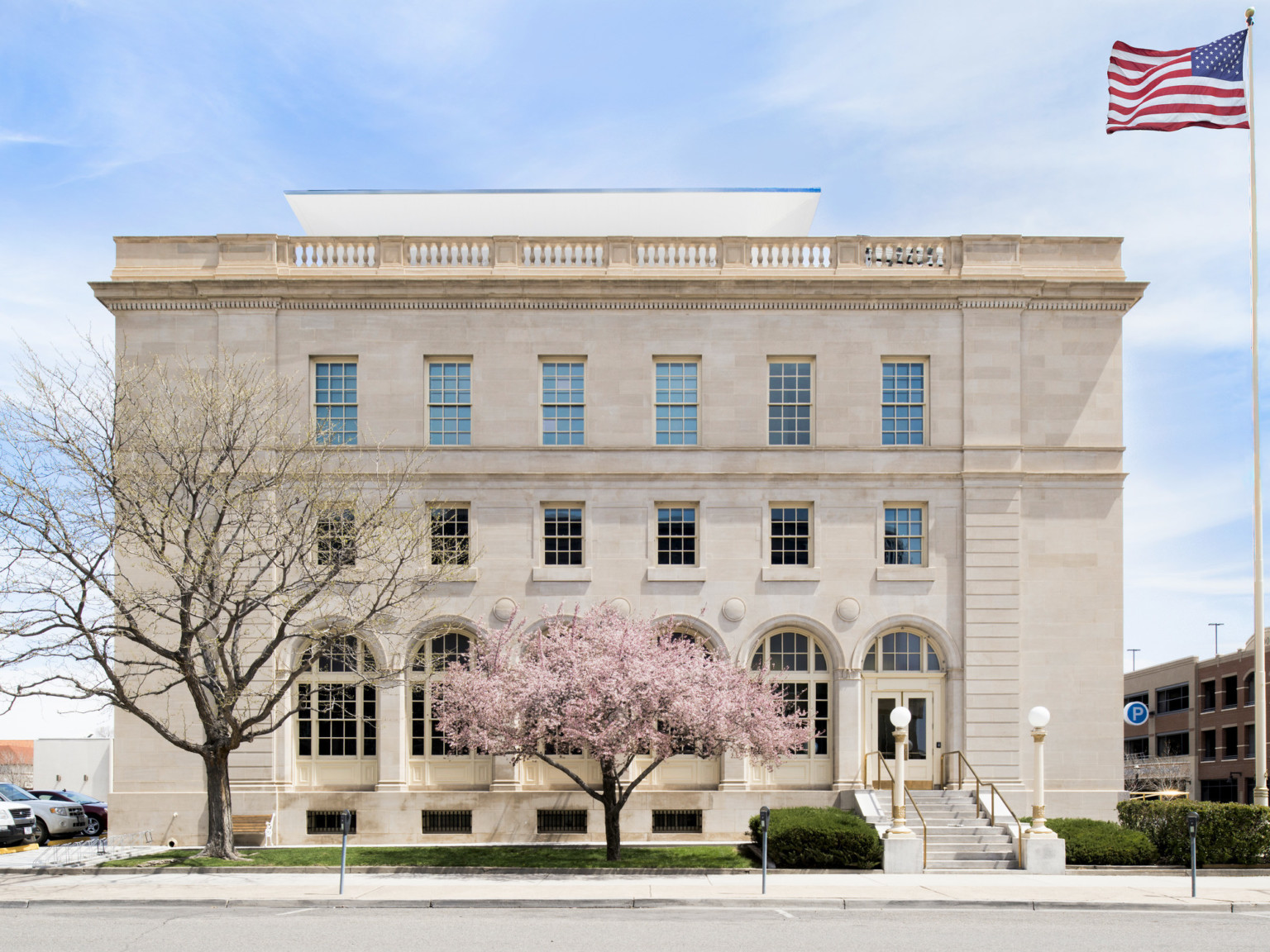 The historic Wayne Aspinall Federal Building with a flowering pink tree in the foreground