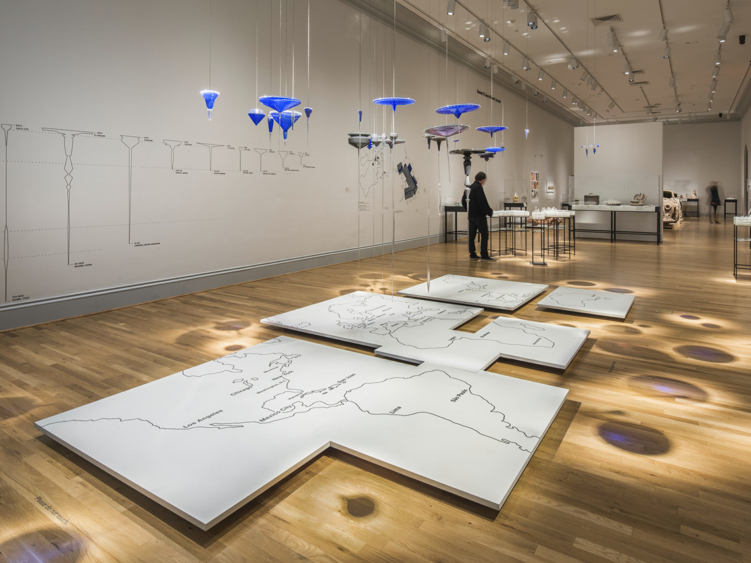 White gallery with wood flooring displays multimedia art