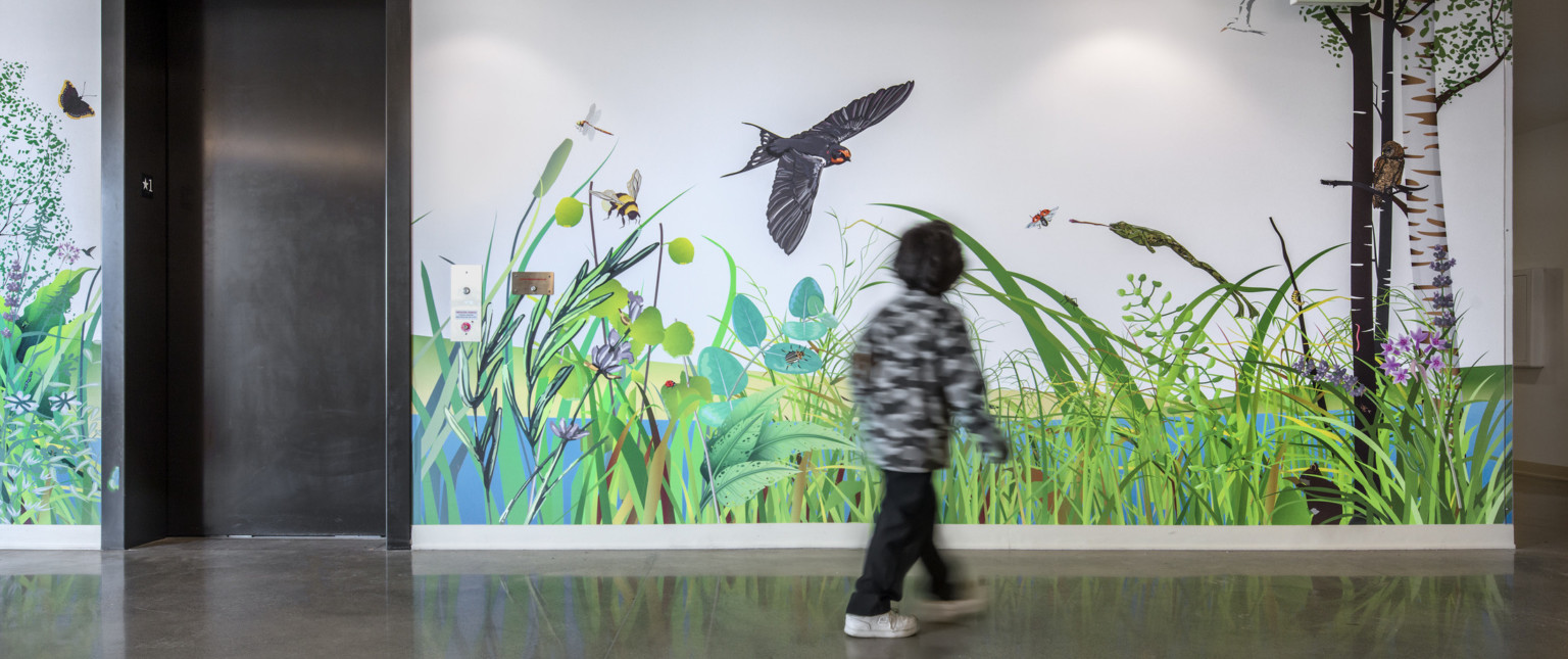 Closeup of child looking at mural next to elevator