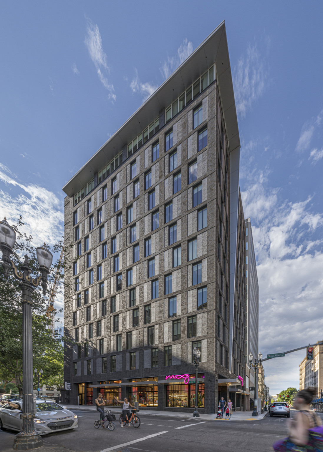 The hotel viewed from across the street. A grey overhang at the top of the building wraps down along the side at the center