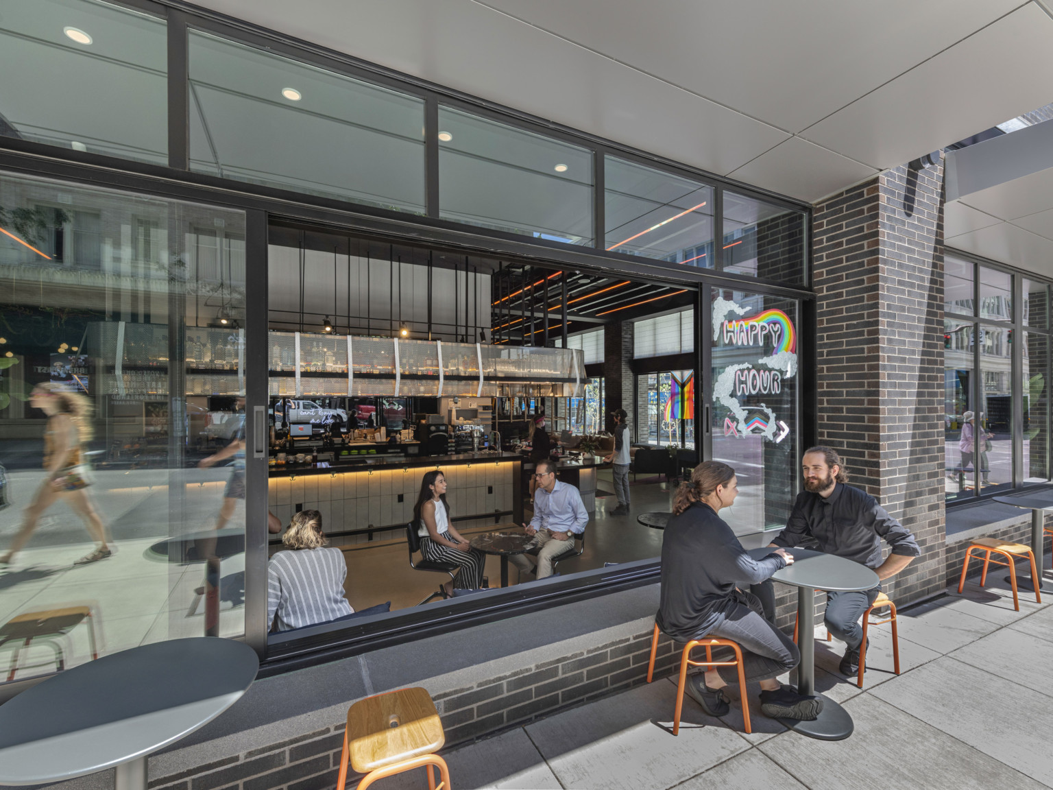 Closeup of combined indoor outdoor seating area, windows slid open. Inside a white restaurant counter is visible.