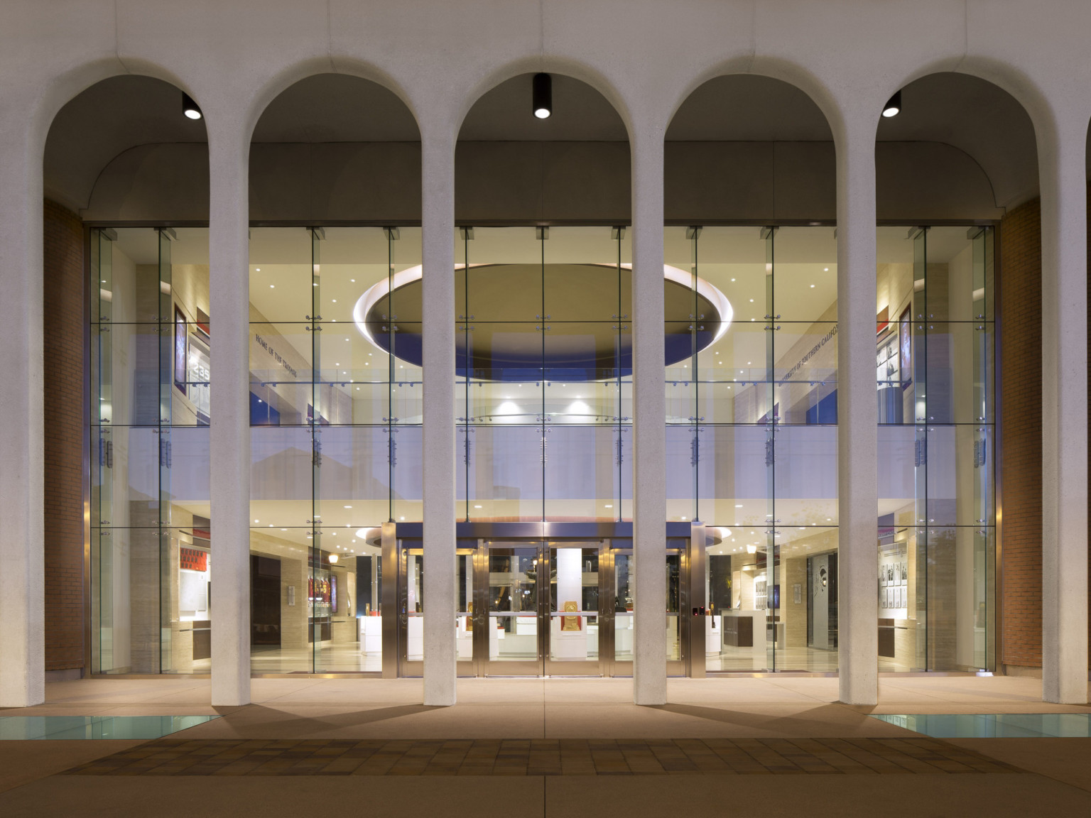 White archways in front of double height windows, illuminated from within