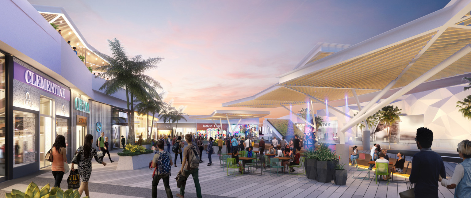 Upper level walkway with white shelter, right, over seating. Shops along left with covered seating above. Trees and greenery