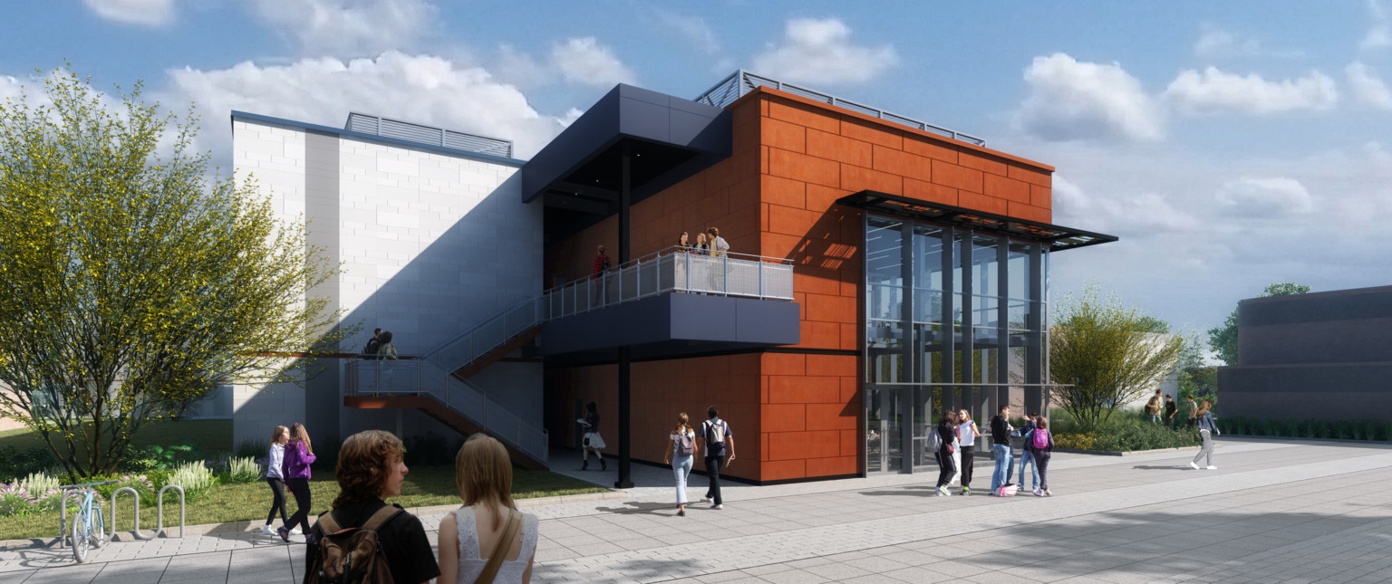 Double height window building entry partially shaded by awning inset on orange building lobby. Connected white building, back