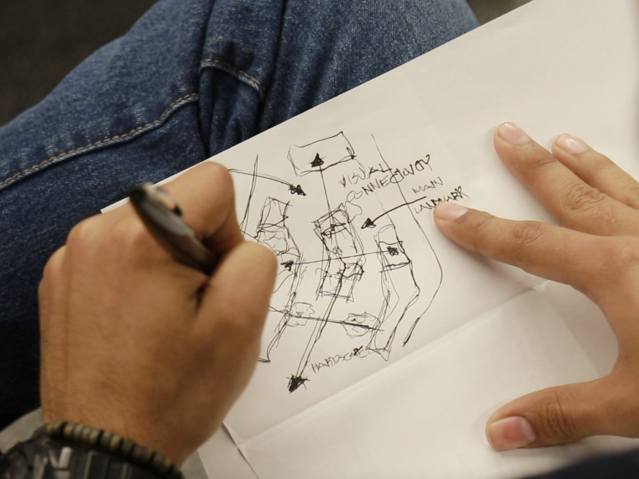 Close up view of student sketching a site plan with labeled arrows