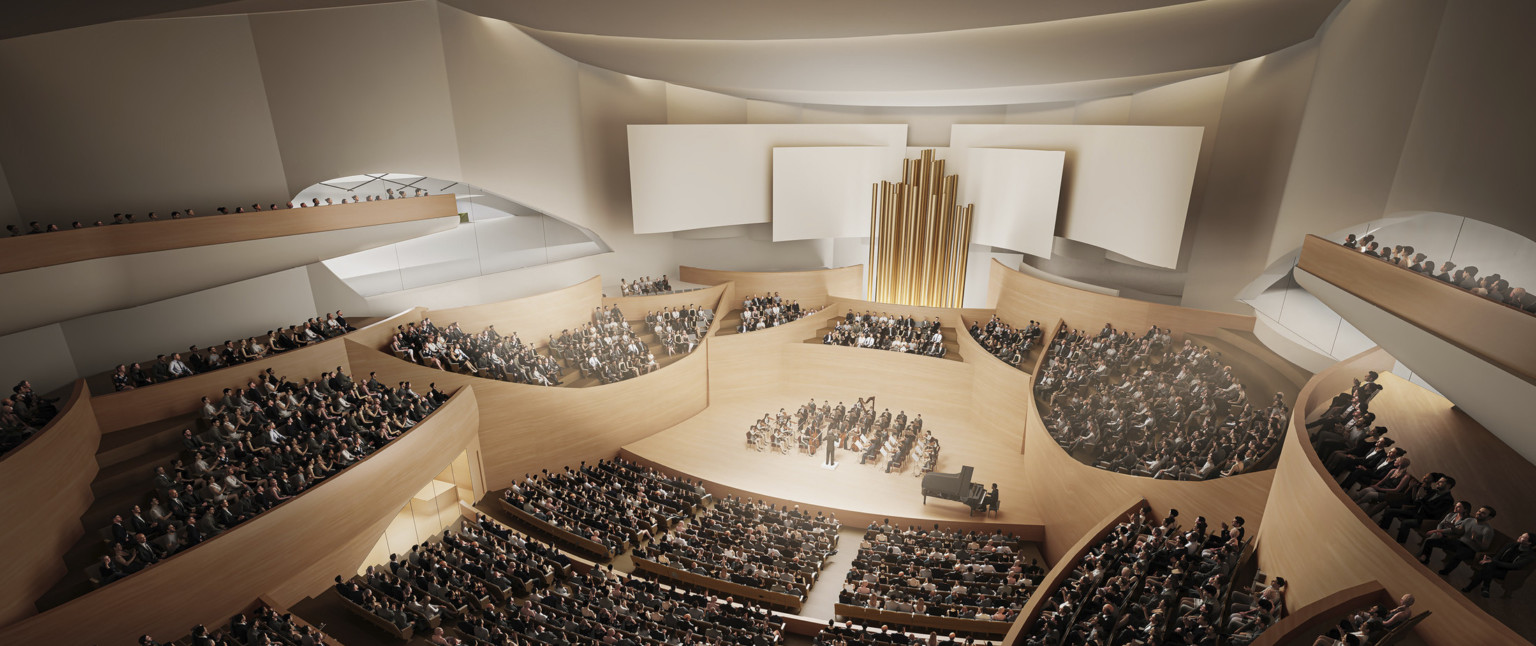 Theater interior with light wooden balconies surround the stage, behind center seating gold pipes with white acoustic panels