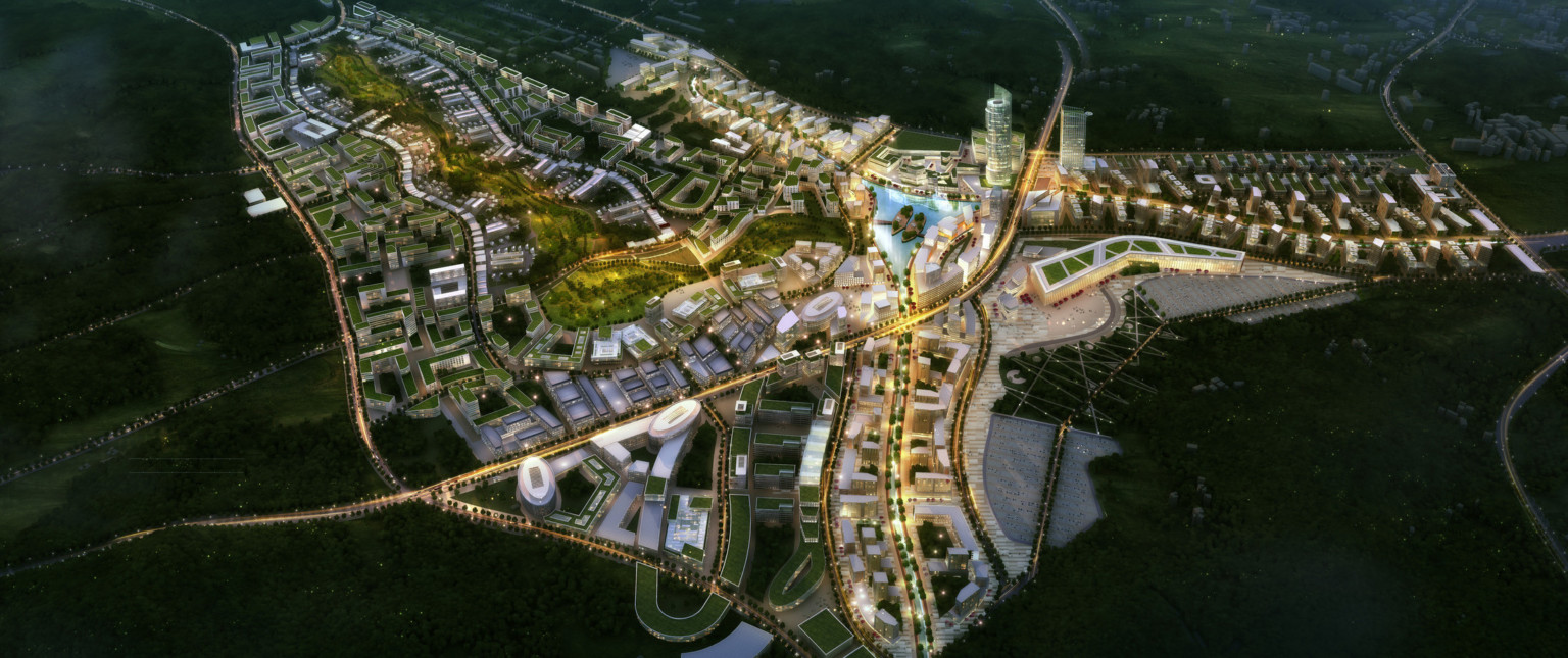 Smart City Korea illuminated at night with green roof buildings and a large park curving towards lake