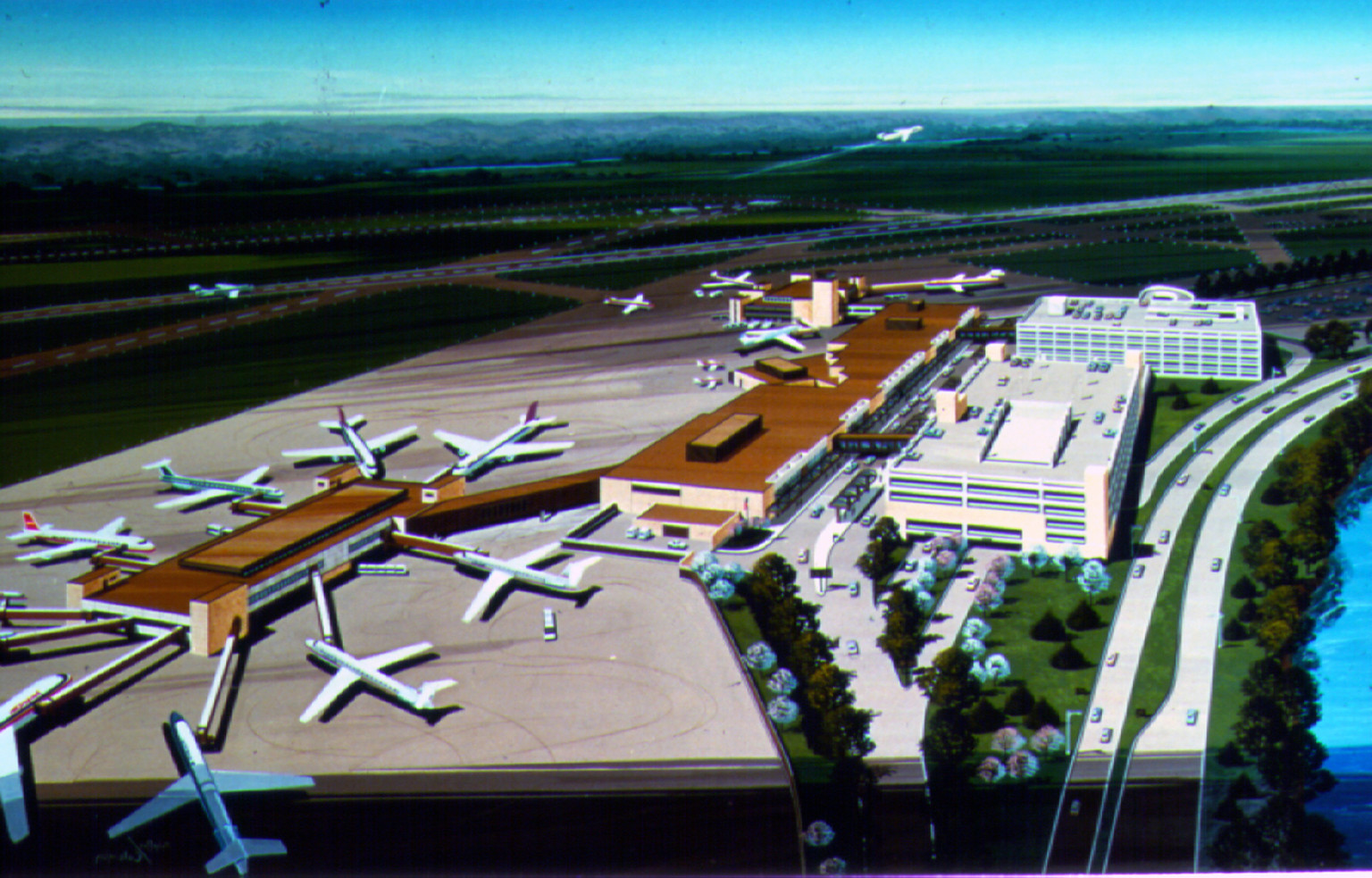 Aerial view of Eppley Airfield in Omaha. Planes on ground surround terminal connected to airport. Planes take off in distance