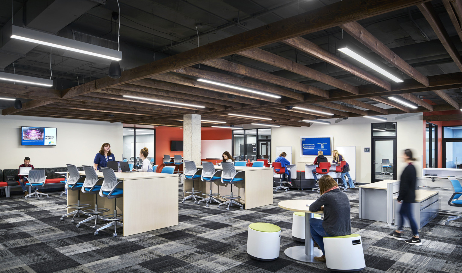 multiple student collaboration areas with flexible seating under wood panel drop ceiling accent in white room with screens multiple student collaboration areas with flexible seating under wood panel drop ceiling accent in white room with screens