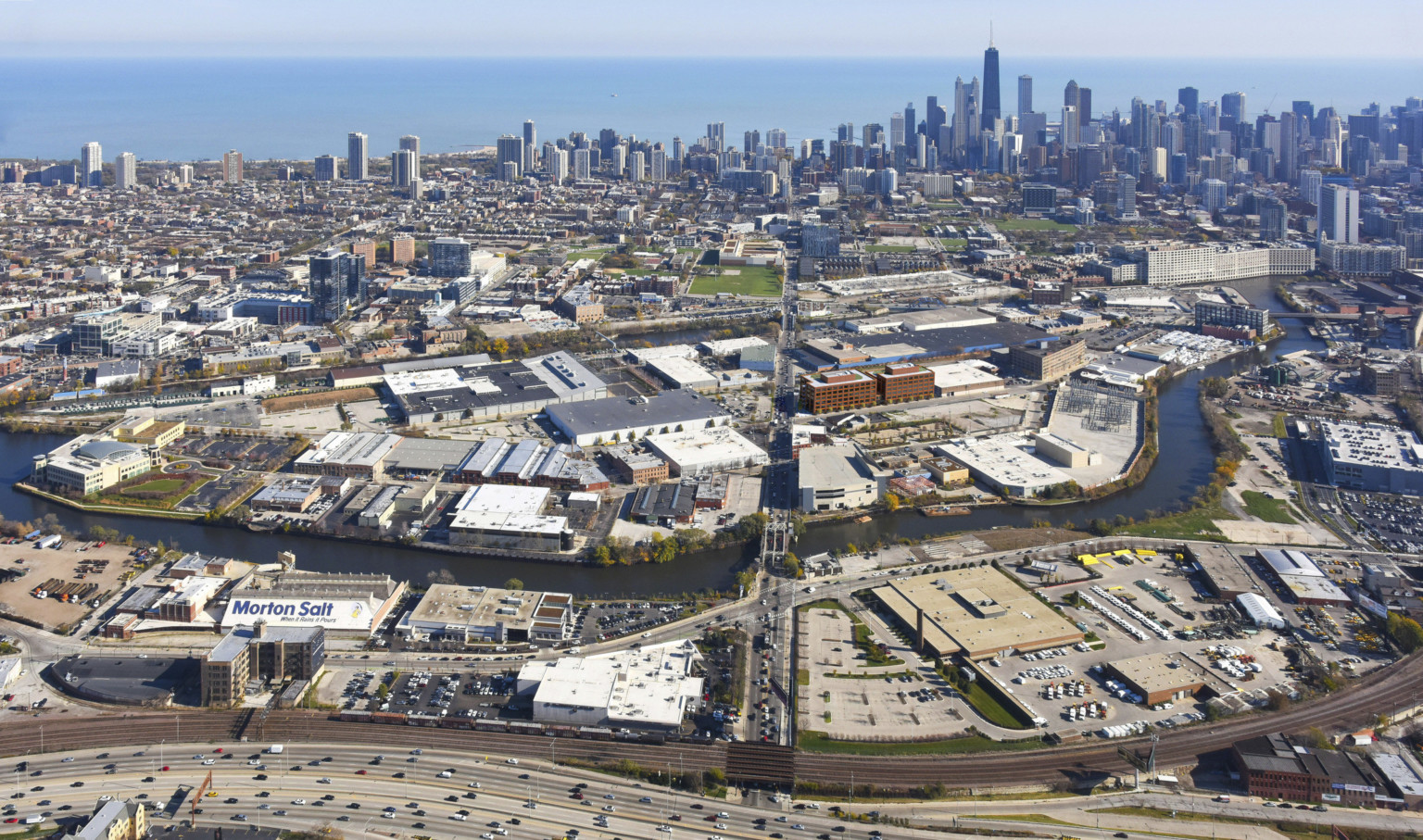 Aerial view of the city of Chicago with cars driving on interstate and buildings in the background.