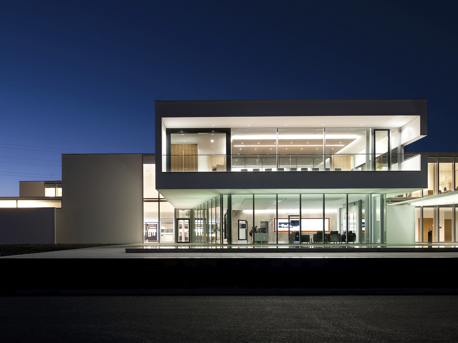 Parker Hannifin European Headquarters, a glass building with white wrapped facade illuminated from within at night