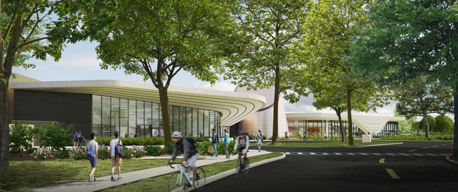 single story building with curving roof viewed from the street with people walking past and cyclists in road