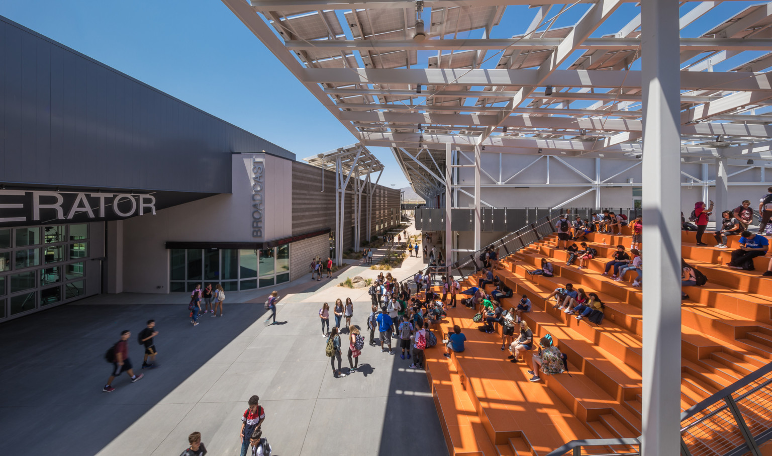 orange bleacher seating shaded by a solar panel canopy