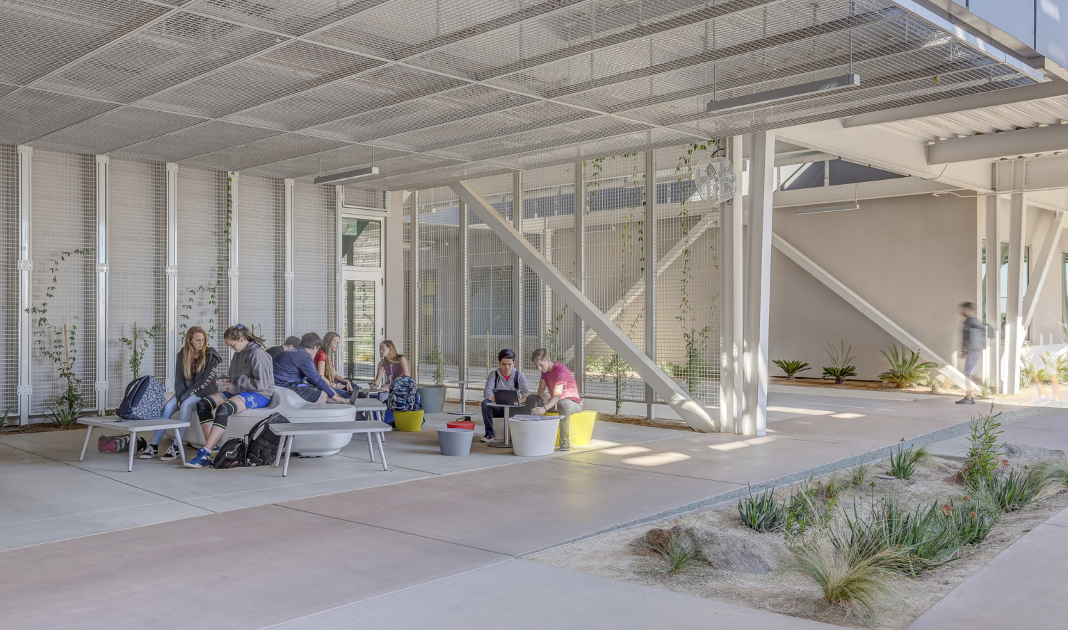 A seating area off a path partially shaded by solar panels