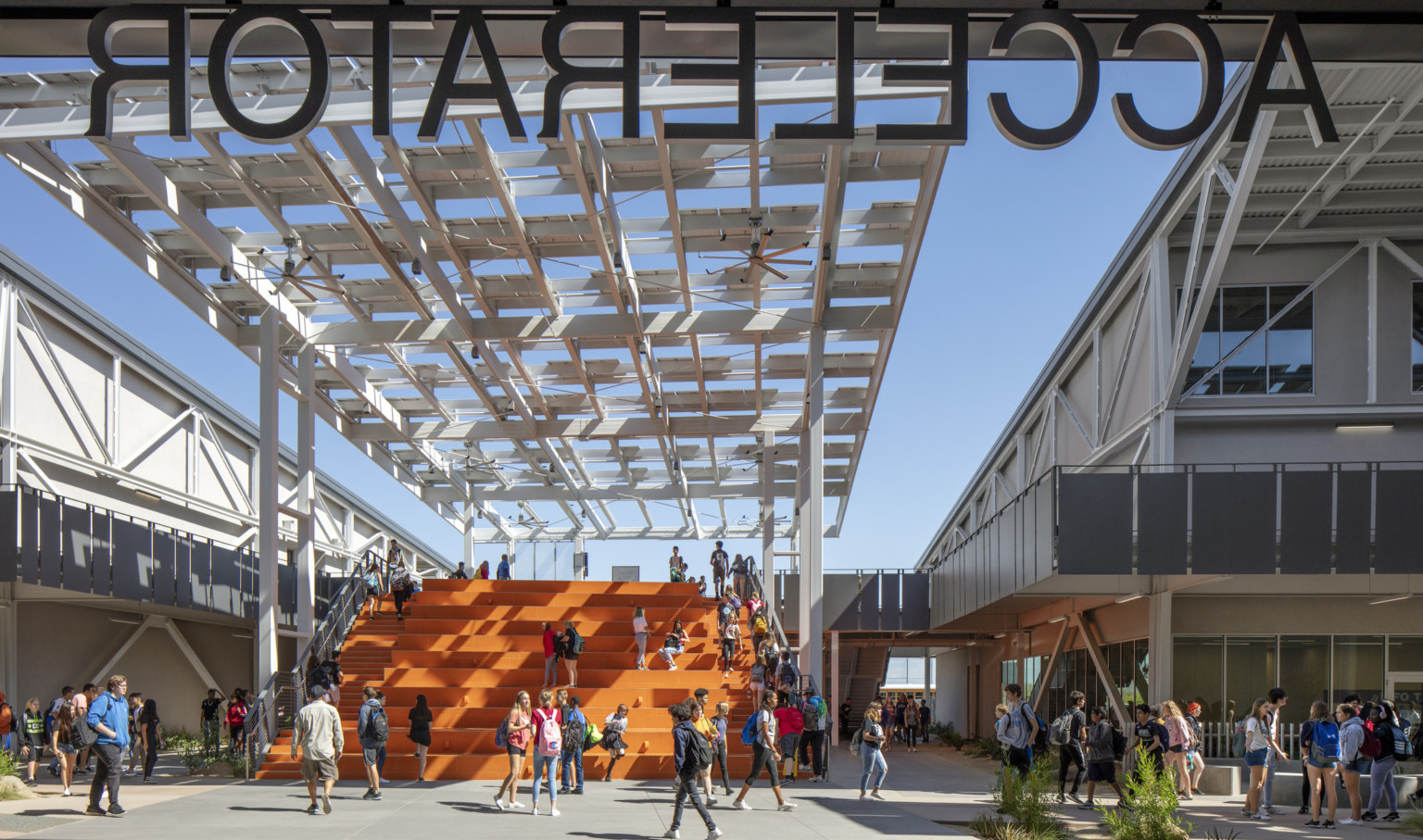 View from under the Accelerator sign looking out to orange bleacher steps partially cover by a solar canopy