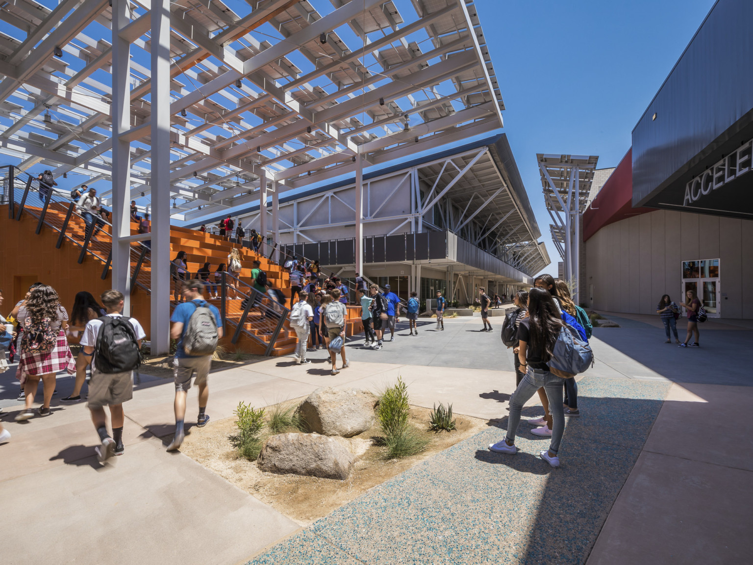 At the front of a walkway between buildings is a large orange partially covered staircase