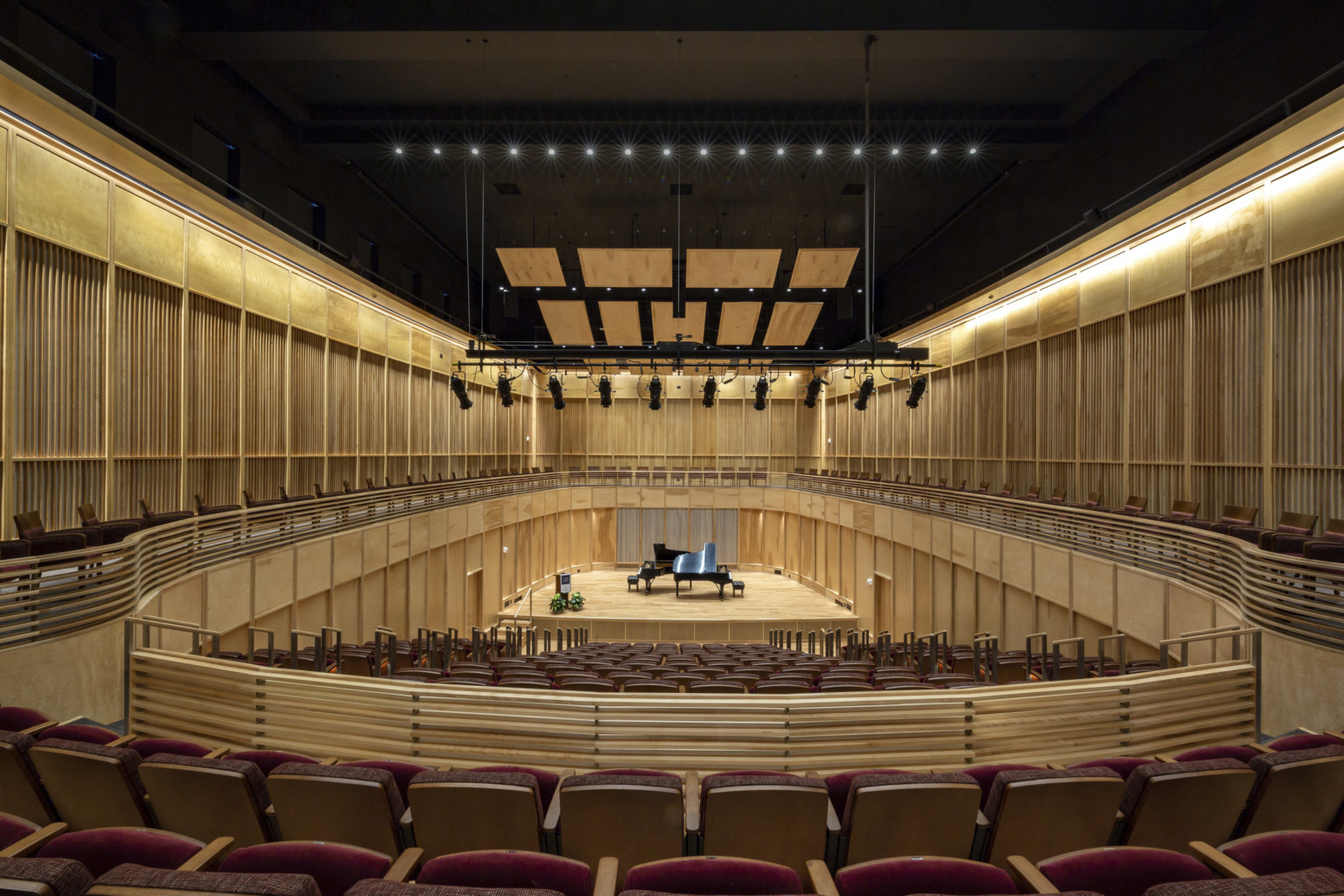 a concert hall with wood finishes and a black ceiling