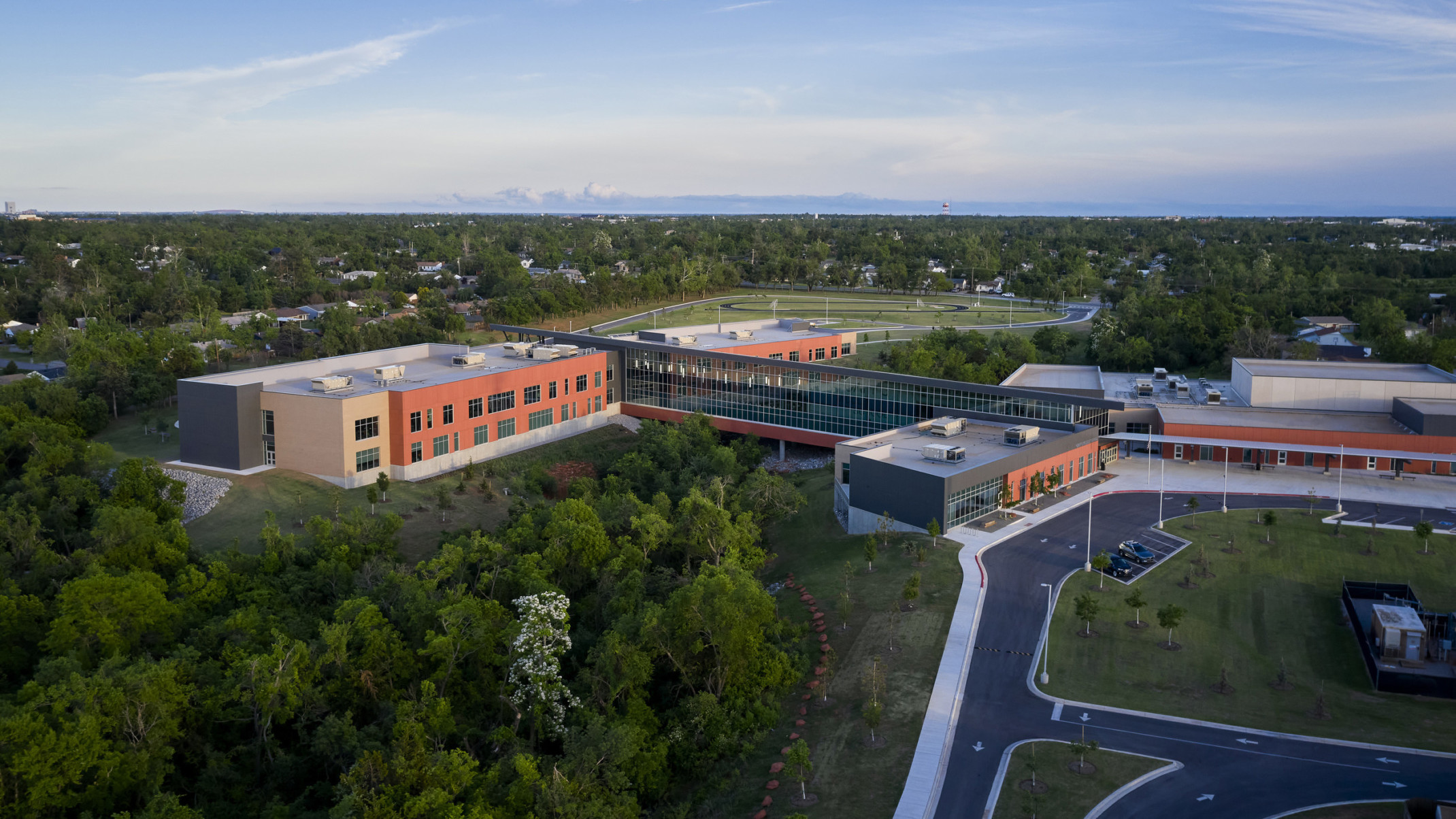 Capps Middle School viewed from above. A round driveway leads to front entrance. A long windowed hall connects 2 buildings
