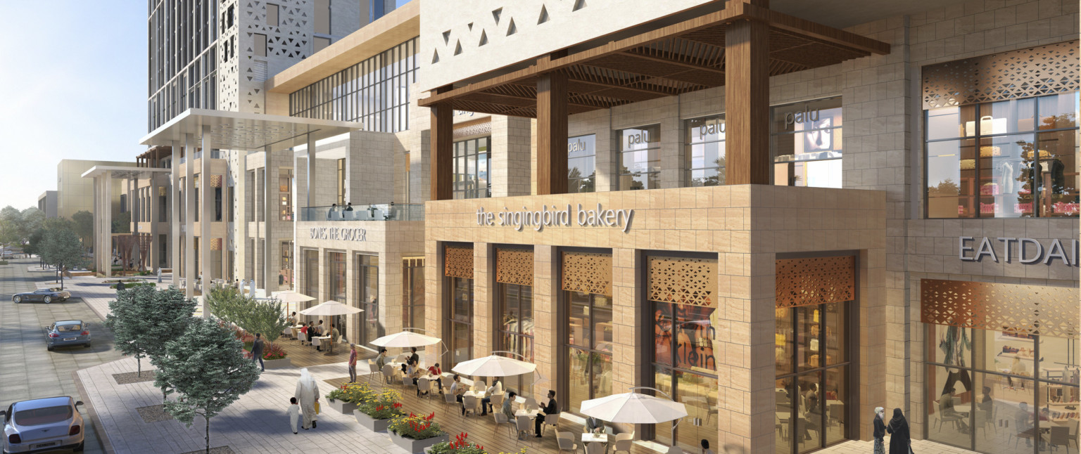 Long stone building with triangular cutouts and gold accents. White triple height shelters over entrances