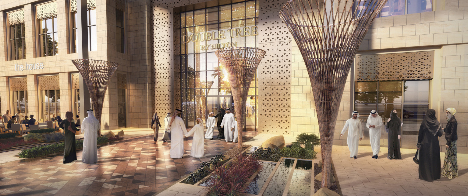 Madinah Gate, a glass and light stone mixed use building with gold accents. In front, tables with white umbrellas and chairs