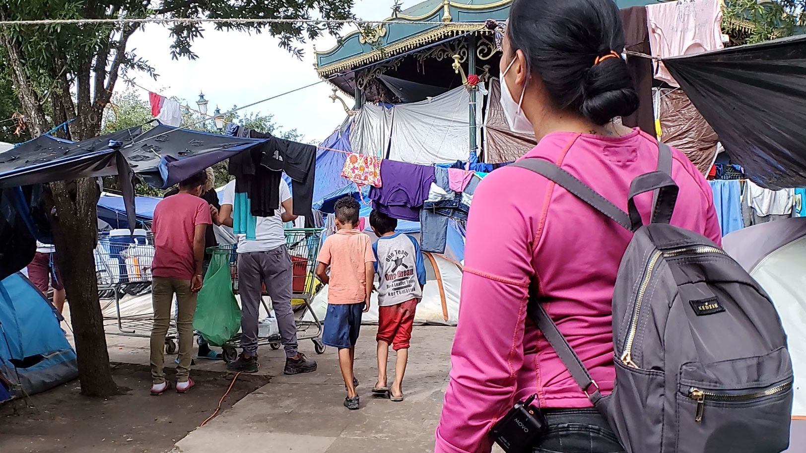 a woman wearing a backpack at a migrant camp in reynosa mexico