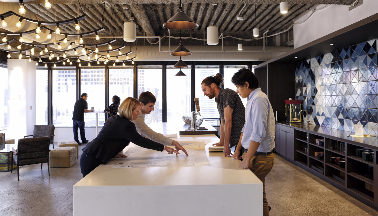 team collaborating over design drawings at an office space in Los Angeles