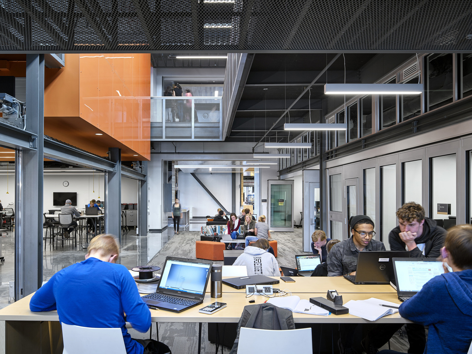 students collaborating in common space with exposed structure and views up to the second floor at the missouri innovation campus