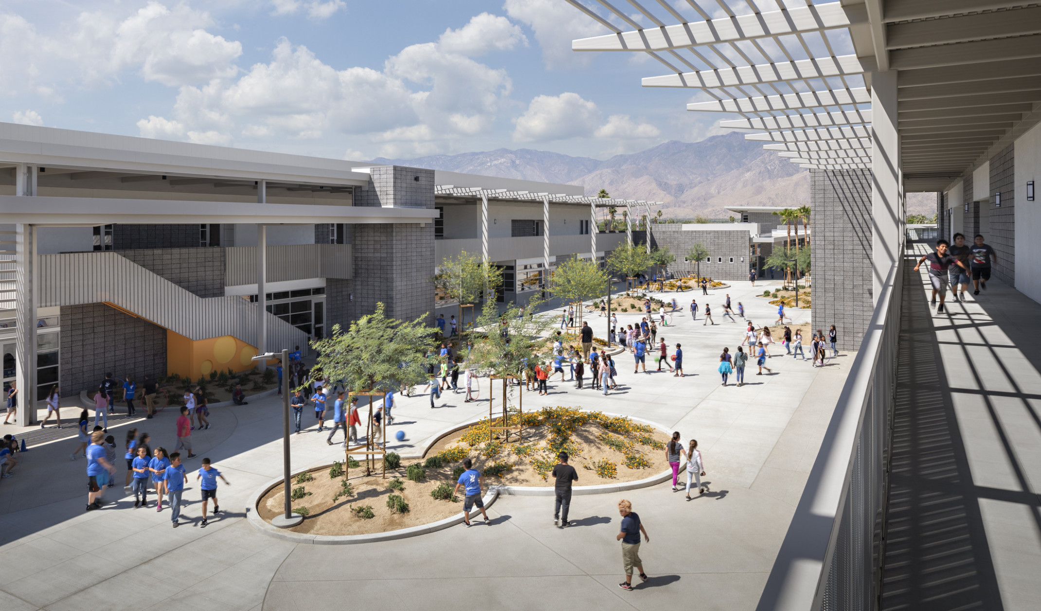 Agua Caliente Elementary School courtyard viewed from 2nd floor exposed walkway. Round garden spaces between 2 story building