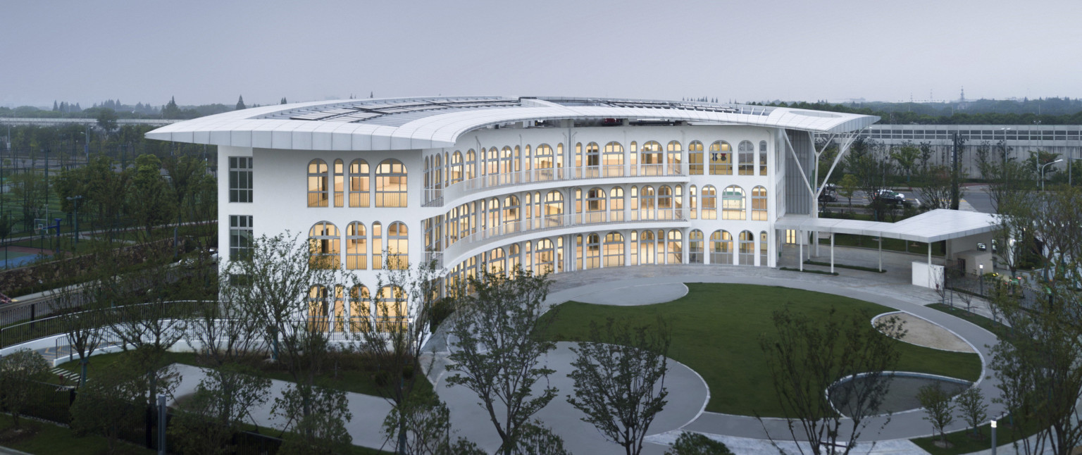 Suzhou Greenshore LOT 16 Kindergarten with semi circular facade and covered driveway to right. Arched windows line front, side