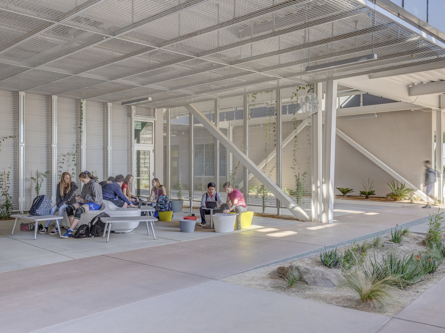 A seating area off a path partially shaded by solar panels