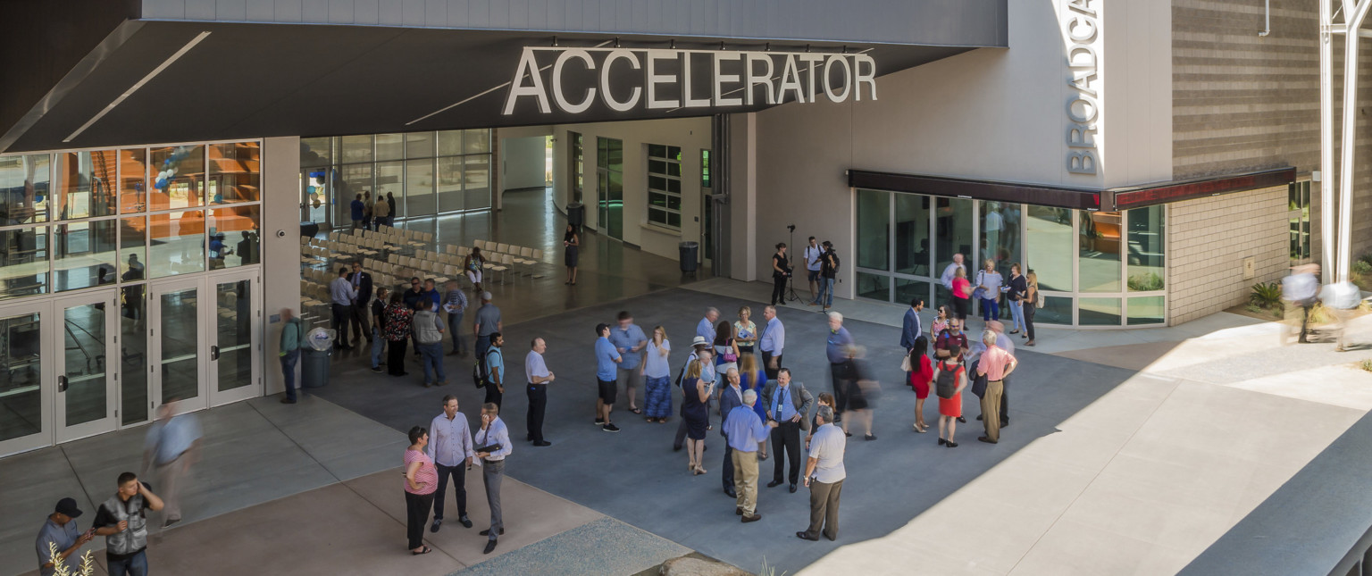 Section of building labeled Accelerator has an angled black roof above wall opening up a seating area to the patio