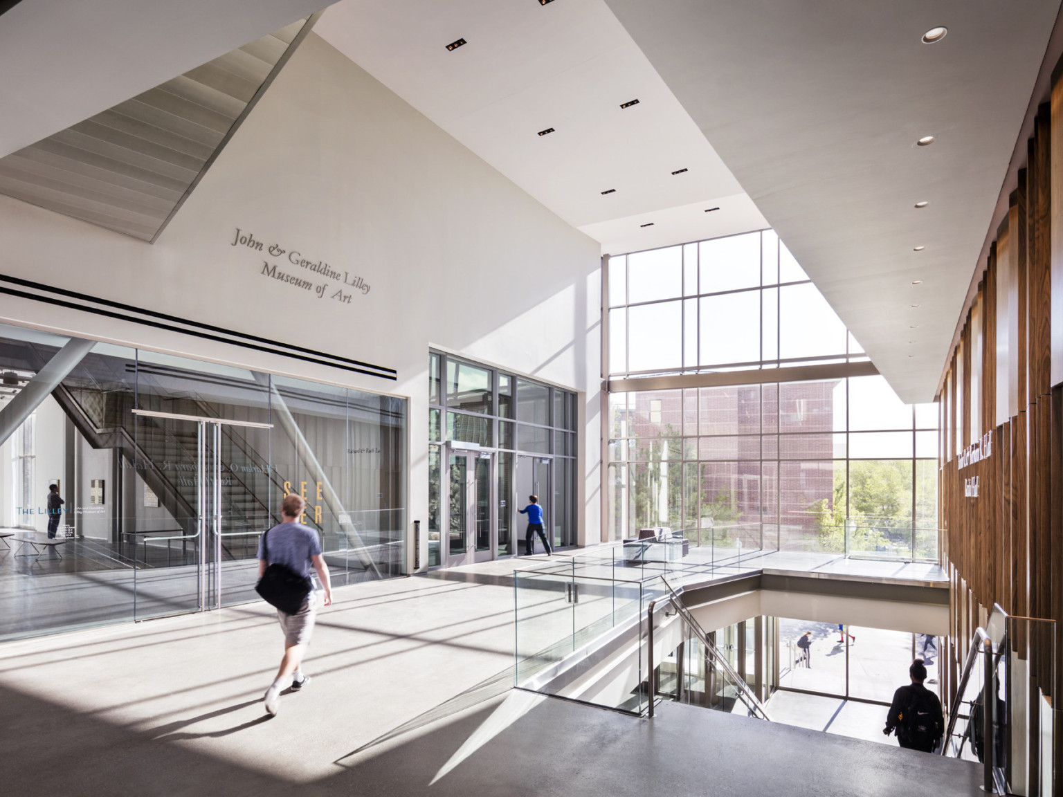 students walk through multistory lobby with angular ceiling