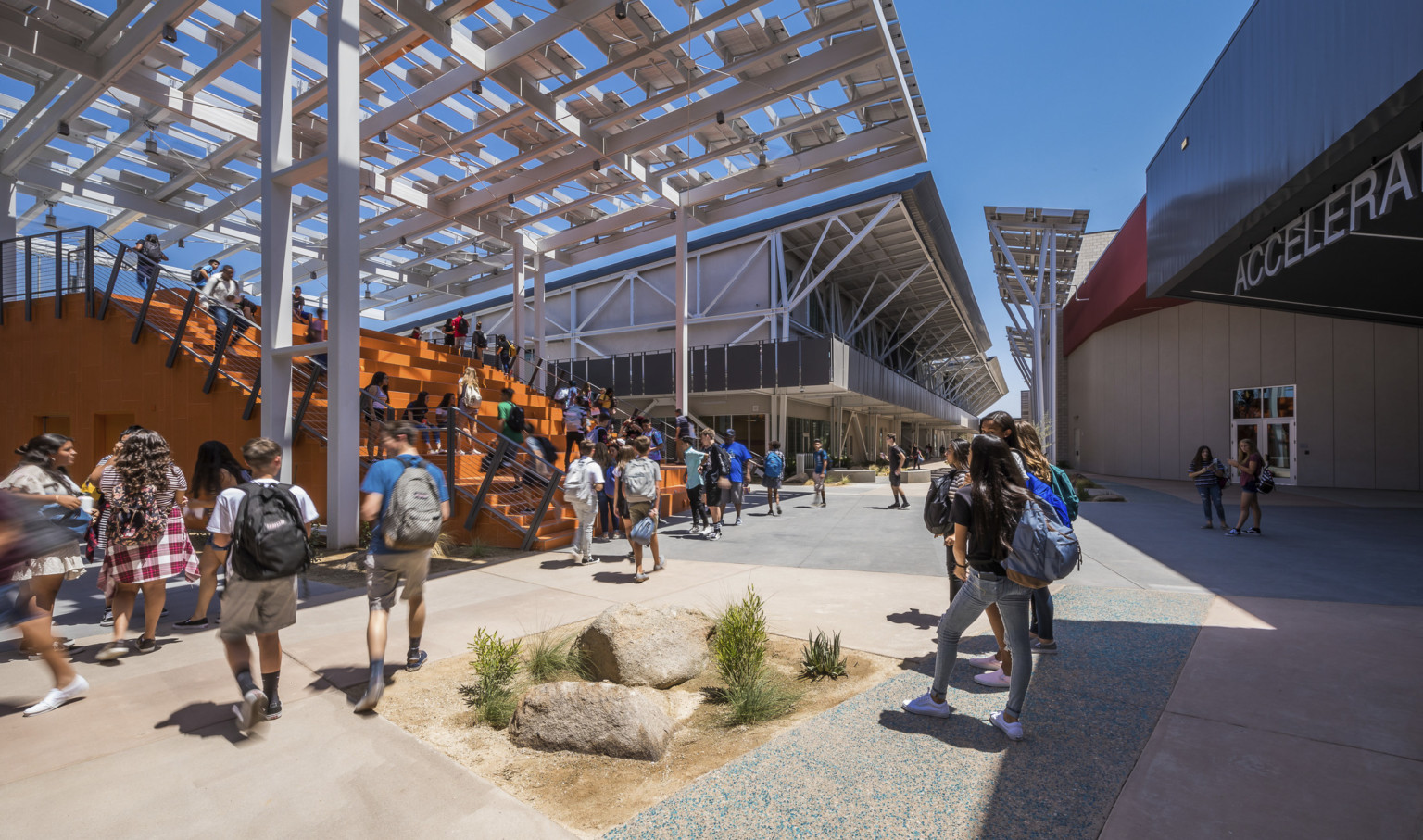 At the front of a walkway between buildings is a large orange partially covered staircase