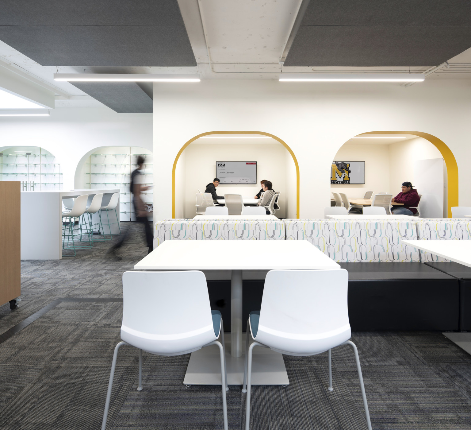 White tables and chairs in front of archway cutouts