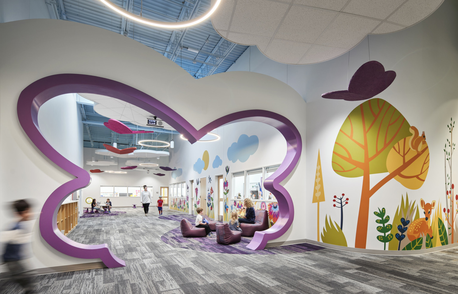 North Kansas City Early Education Center interior hallway with bright mural of trees and abstract-shaped cutout in purple in hall