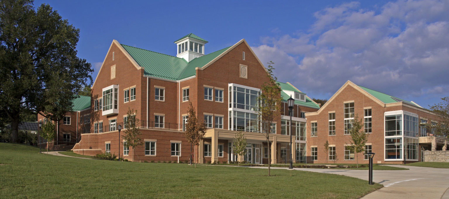 St. Paul’s Upper School, a multistory brick building with green roof and glass wall accents. Brown covered entry at driveway