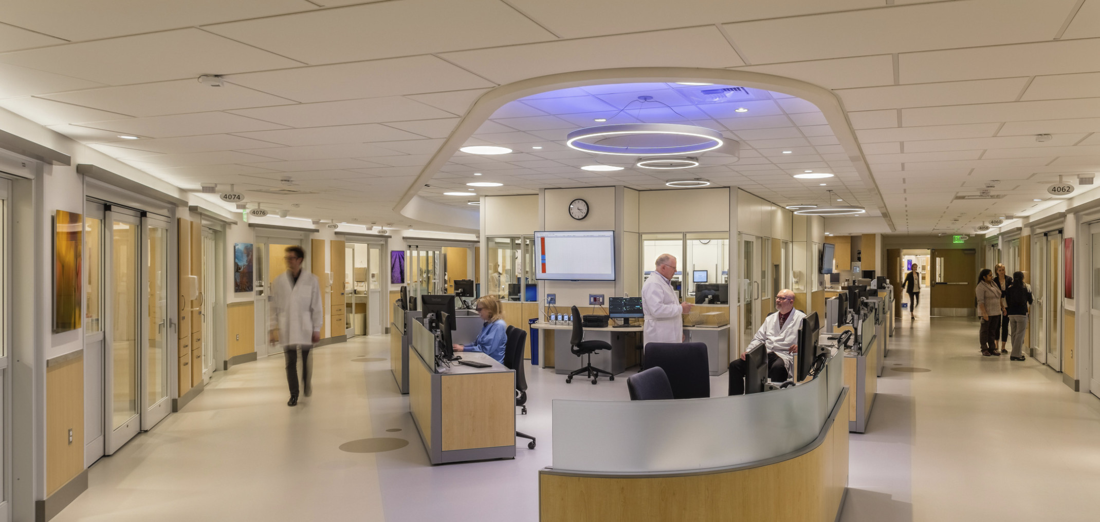 EvergreenHealth Progressive Care Unit with long desk wrapped around corner of hallway with blue and white accent lights above