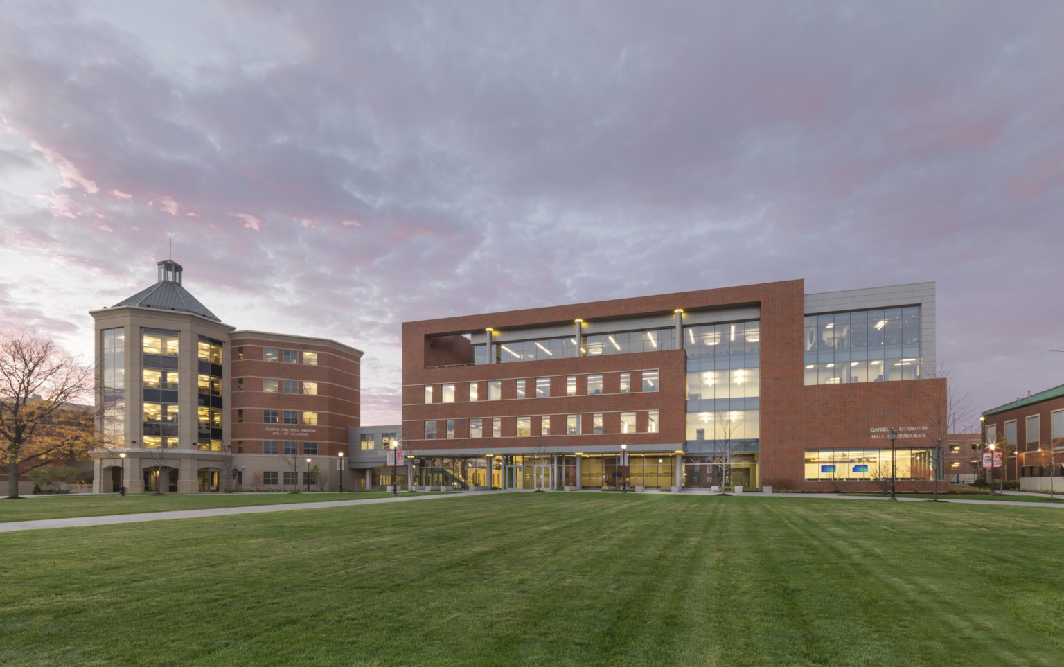 Benedictine University's Goodwin Hall College of Business exterior illuminated from within in the evening, wrapped facade Benedictine University's Goodwin Hall College of Business exterior illuminated from within in the evening, wrapped facade