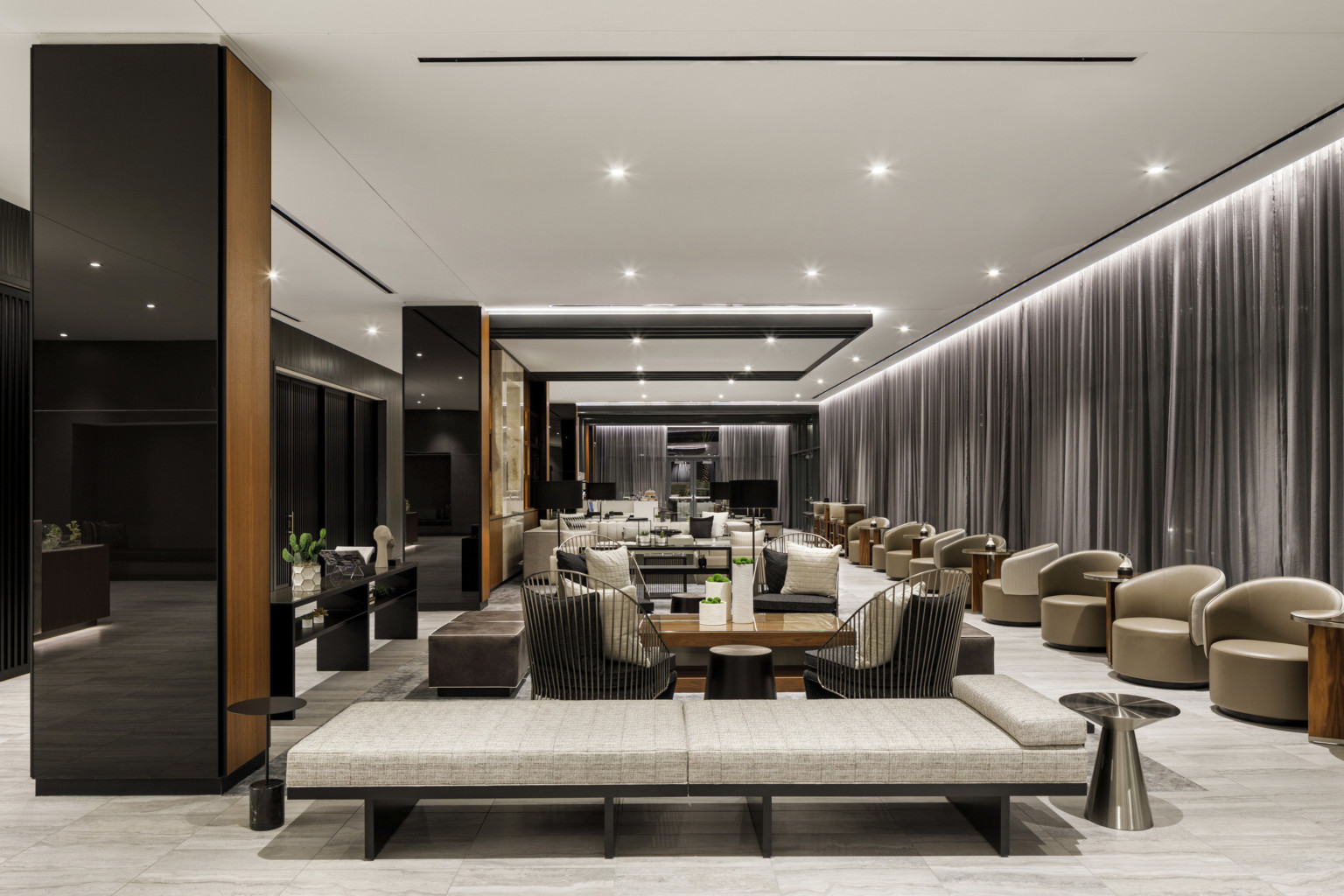 lobby with black mirrored columns white ceiling and gray drapes seating clusters with upholstered chairs and metallic tables