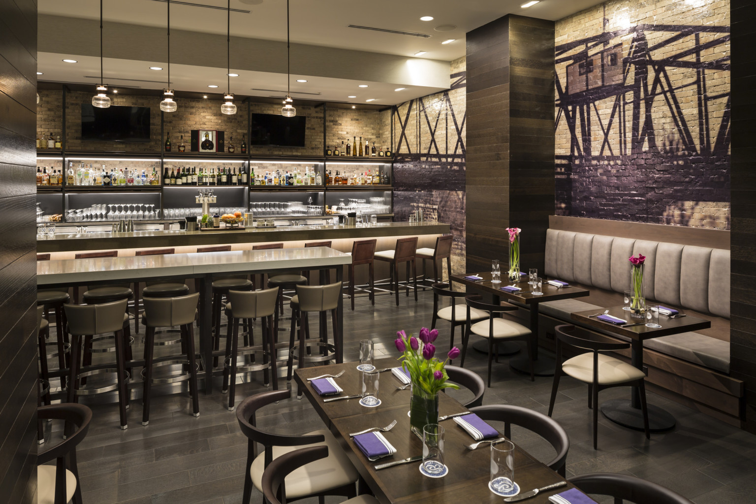 Cedar+Stone, Urban Table restaurant interior with mixed seating, mural on exposed brick wall, and hanging pendant lights