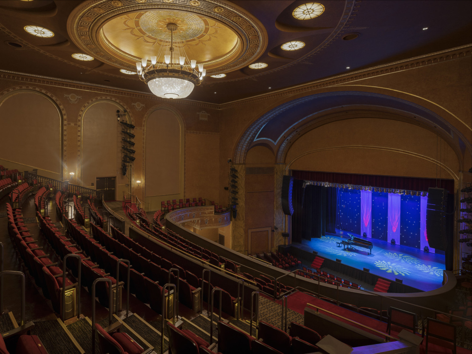 Historic State Theater in New Brunswick New Jersey renovated seen from balcony, ornate chandelier, colorful stage lighting design