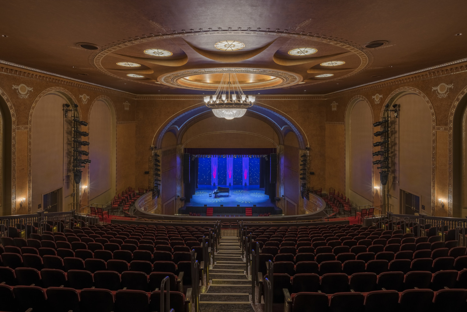 Historic State Theater in New Brunswick New Jersey renovated seen from balcony, ornate chandelier, colorful stage lighting design