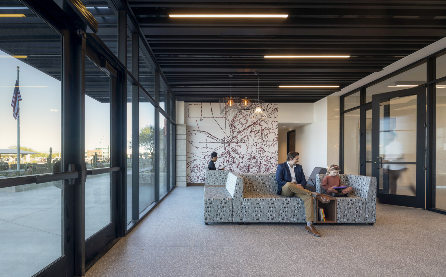 Lobby entrance with glass looking out to the desert, mural on far wall, modern wire geometric shade son pendant lights