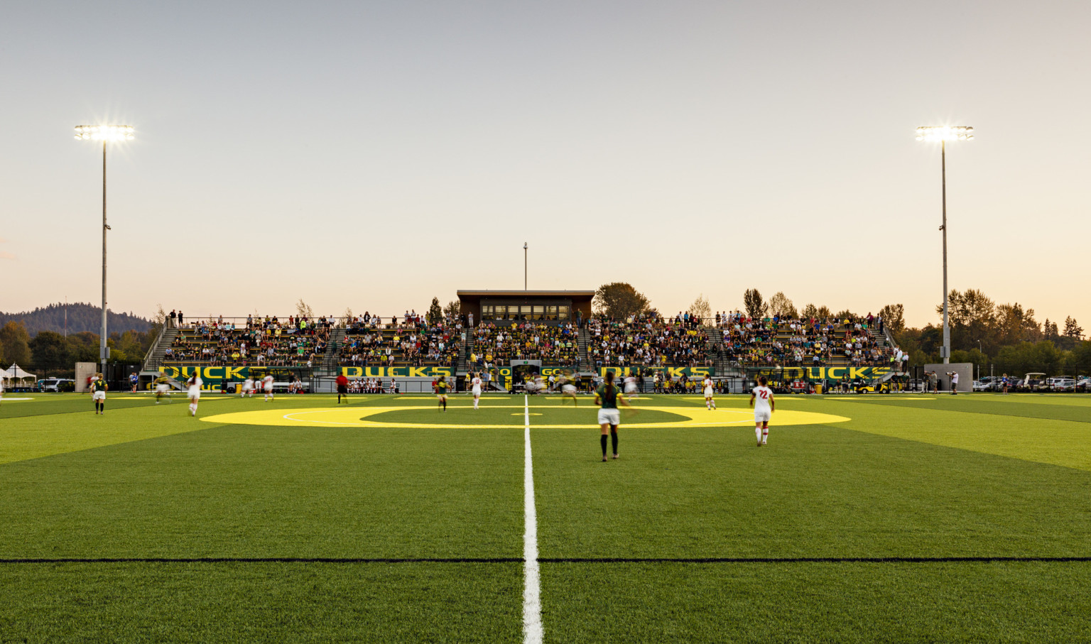 Papé Field, for University of Oregon womens soccer and lacrosse, seen from center line during game, bleachers reading Go Ducks Papé Field, for University of Oregon womens soccer and lacrosse, seen from center line during game, bleachers reading Go Ducks