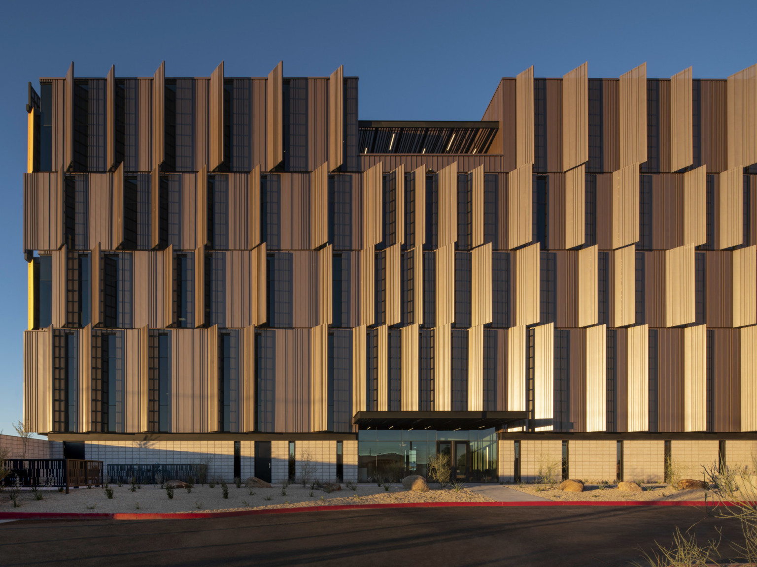 Dusk shot of Pinal County Attorney’s Offices, a serrated wrapped facade in alternating horizontal layers