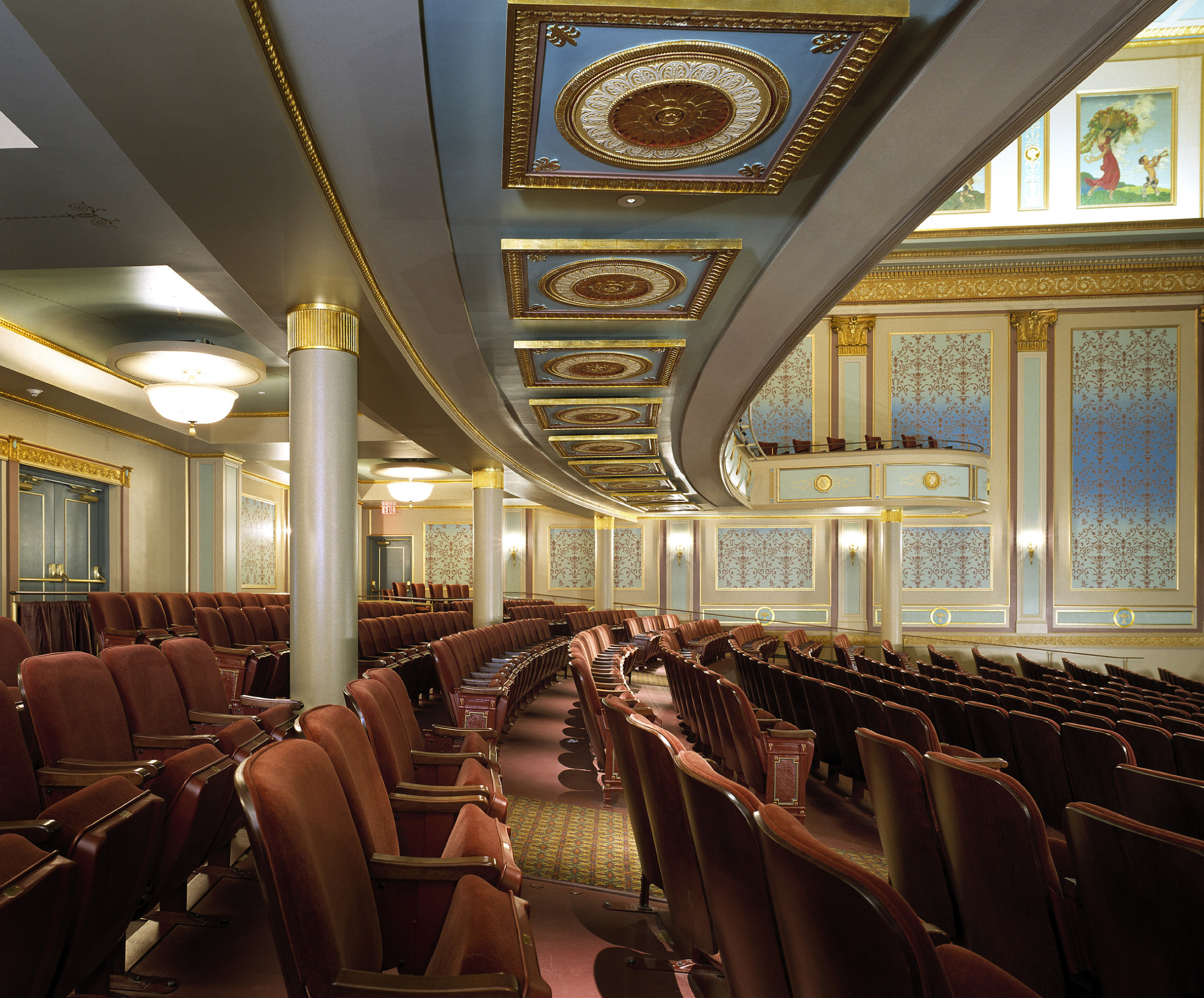 interior of the Stand Theater audience gallery in the Appell Center. gold accents on white walls with blue picture frame mouldings, brown seats