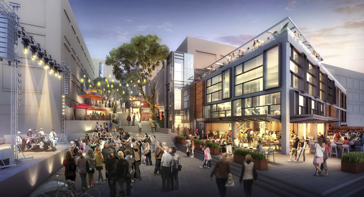 open air plaza lined with trees umbrella covered seating and string lights leading to a stage and low rise mixed use building