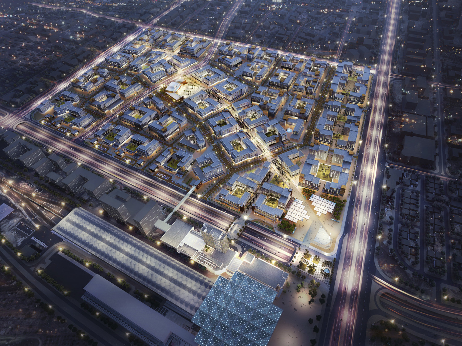 gridded master plan with vehicular street divisions and large commercial buildings with bright lights against dark sky
