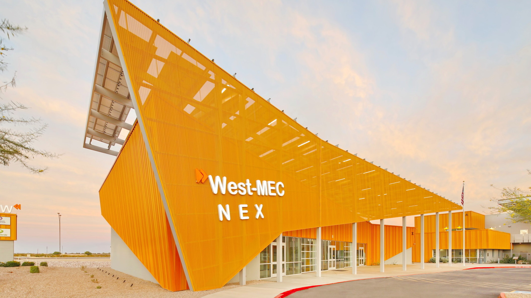 West-MEC NEX building at the Southwest Campus, an angular yellow building with sunscreen across the front with white sign