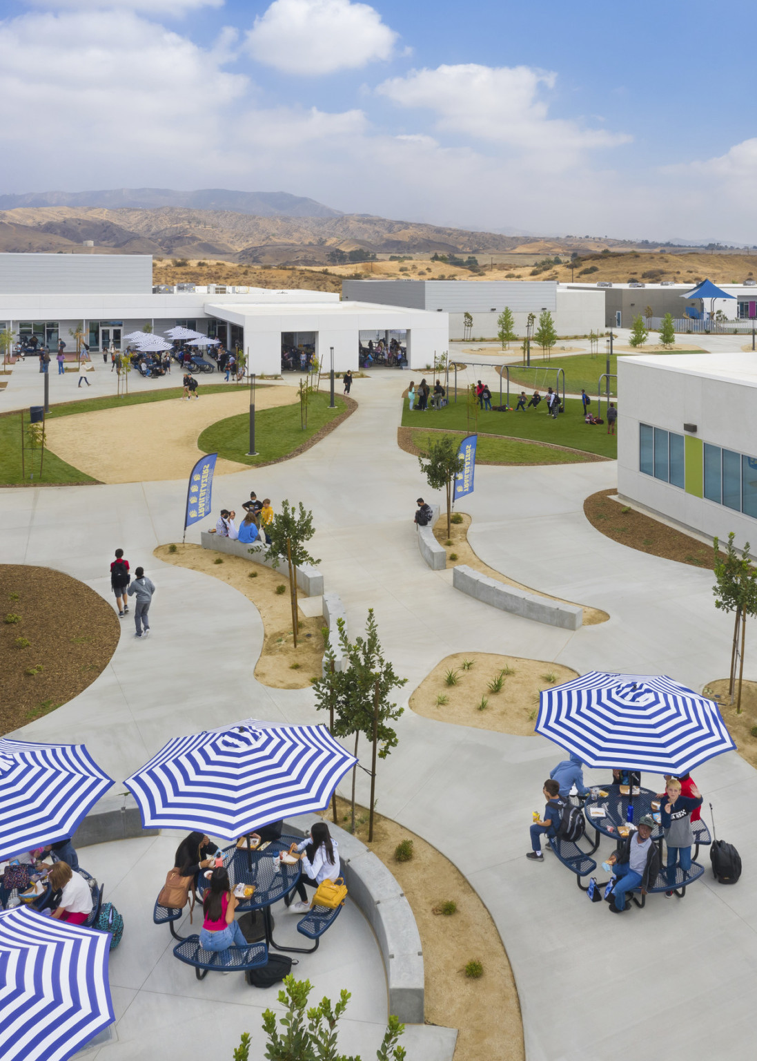 aerial view of central campus with blue and white striped umbrellas overround tables in central park courtyard